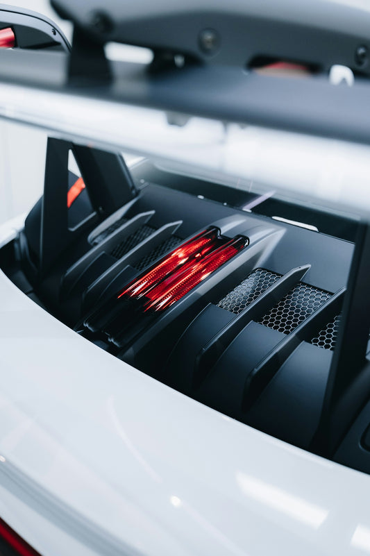 a white sports car with a red tail light
